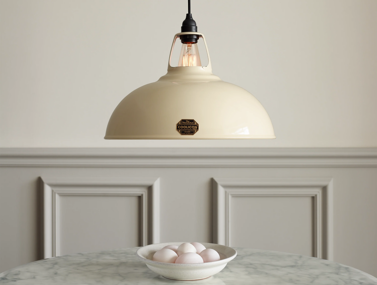 A Large Coolicon Classic Cream lampshade hanging over a marble table. A bowl with duck eggs is placed on a marble table under the shade