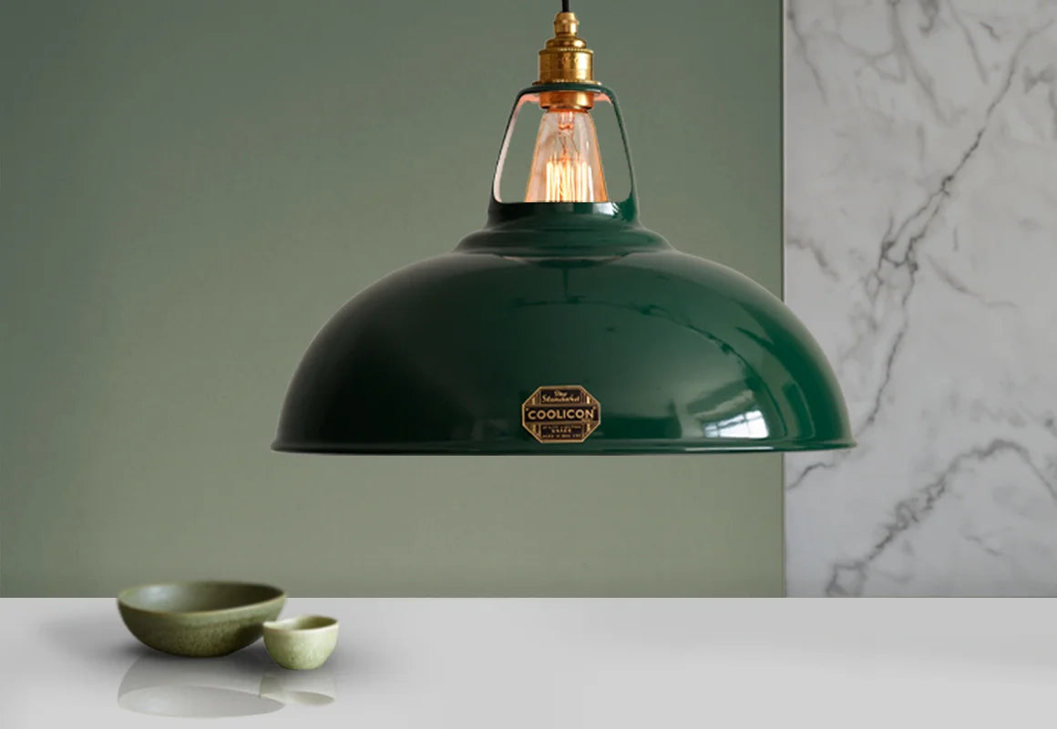 A Large Coolicon Original Green lampshade hanging over a table with two green bowls