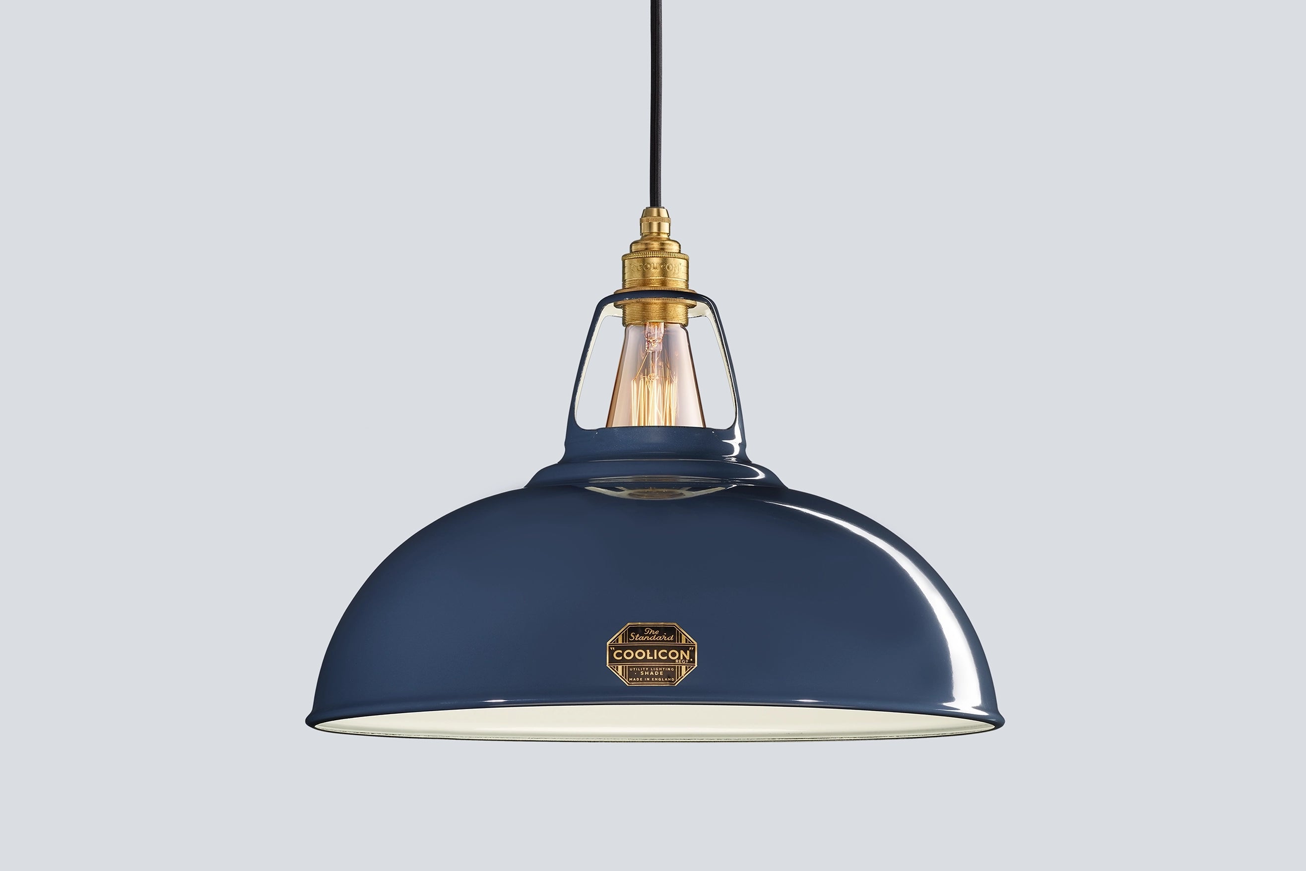 Large Selvedge blue Coolicon lampshade with a Signature Brass pendant set over a light blue background