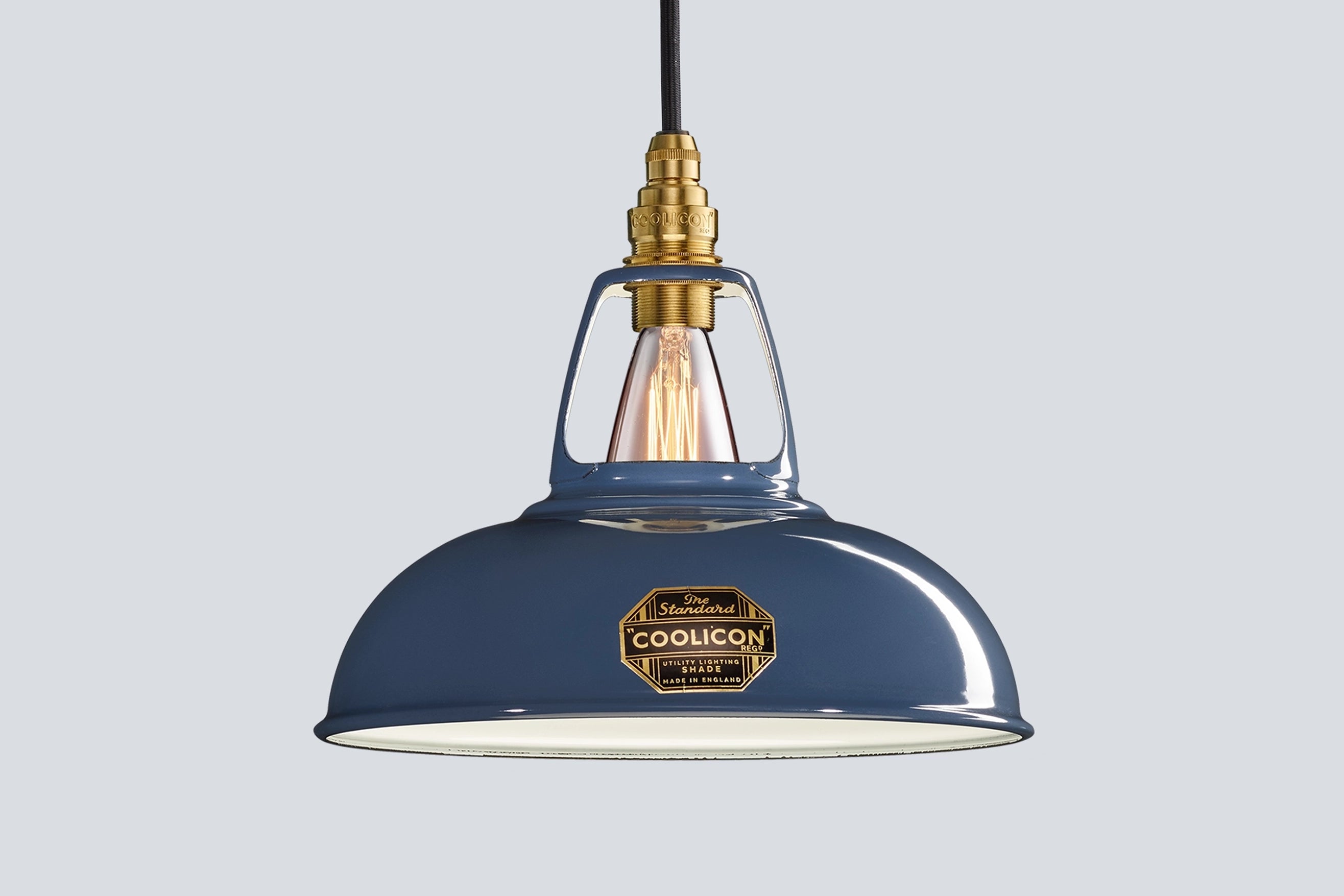 Selvedge blue Coolicon lampshade with a Signature Brass pendant set over a light blue background