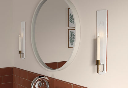 Two candle sconce with a lit candle in a bathroom, next to a mirror